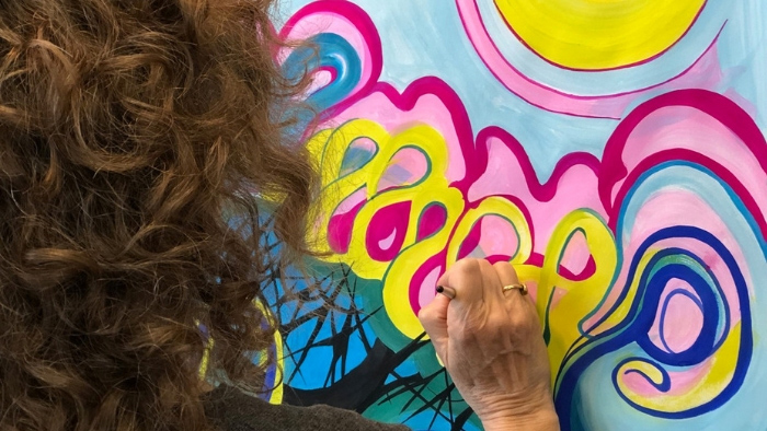 Woman working on brightly colored process painting