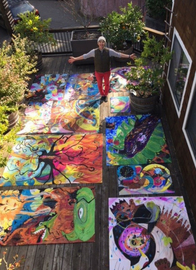 Woman standing outside surrounded by paintings